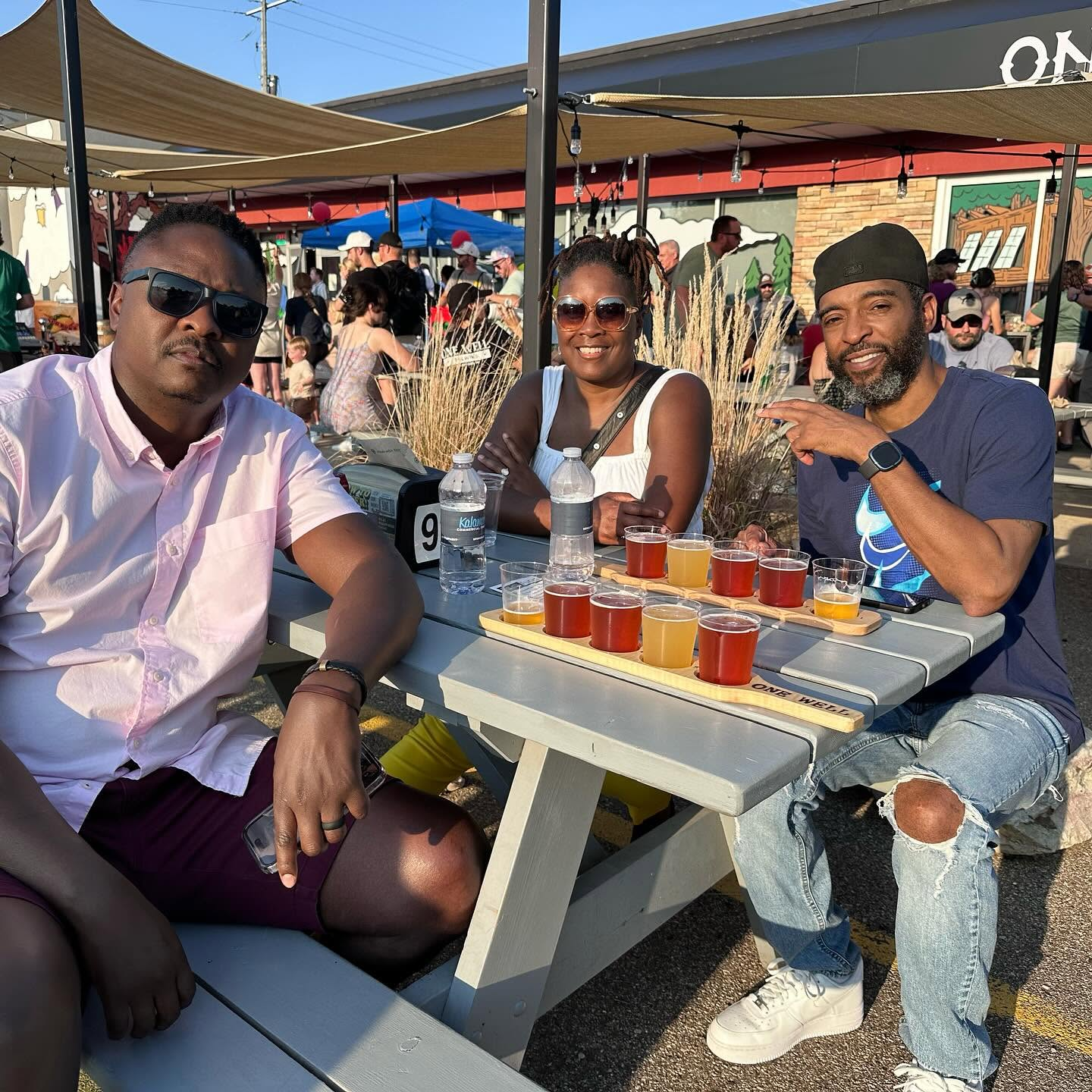 Group of three individuals drinking flights of beer
