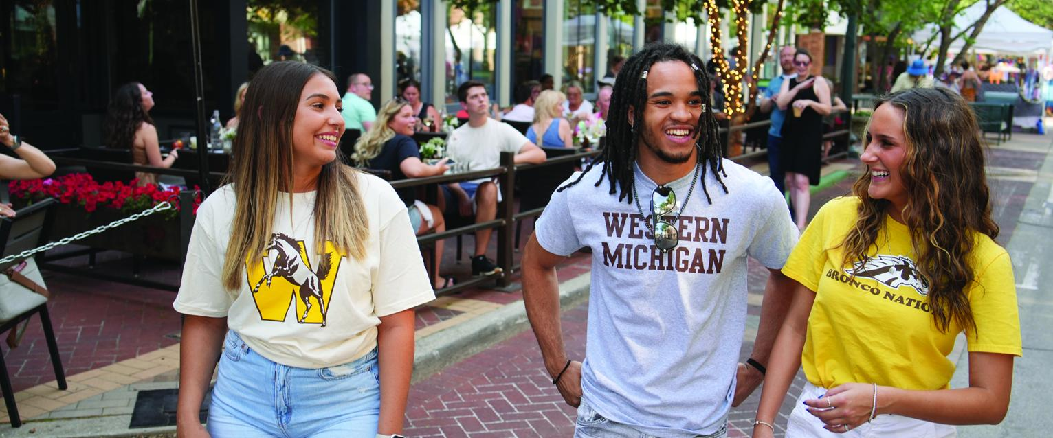 Photo of three students walking together and laughing
